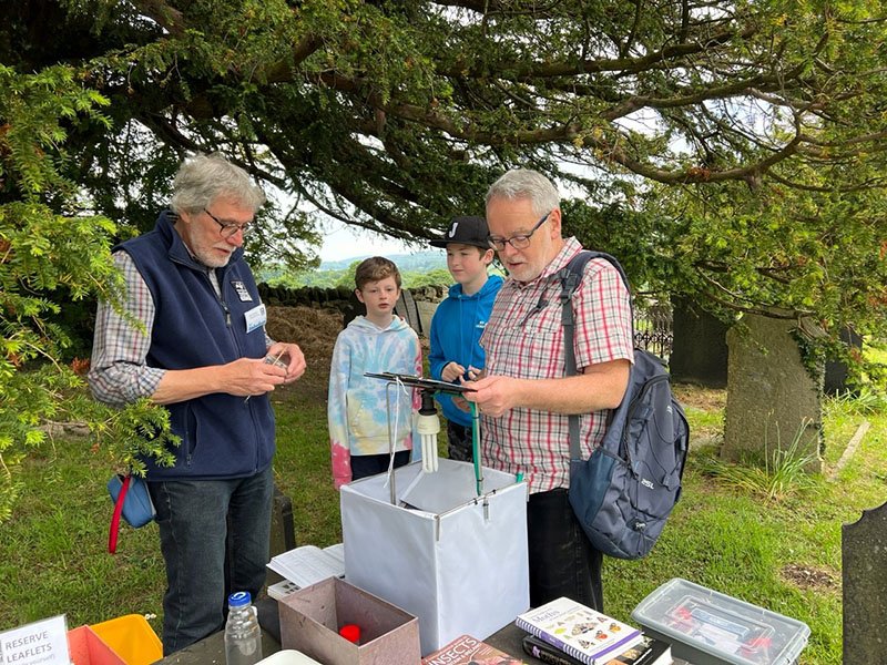people standing around a moth trap